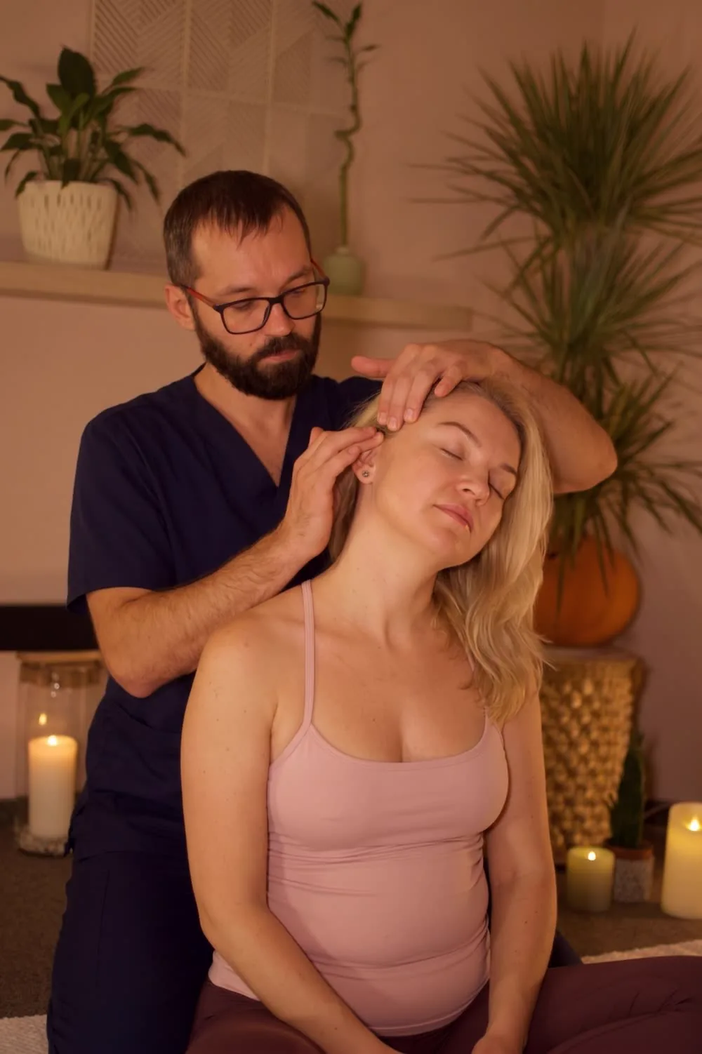 Masaż tajski stóp i głowy w studiu Massage 4 You w Poznaniu - terapeuta pracuje nad karkiem osoby siedzącej na macie