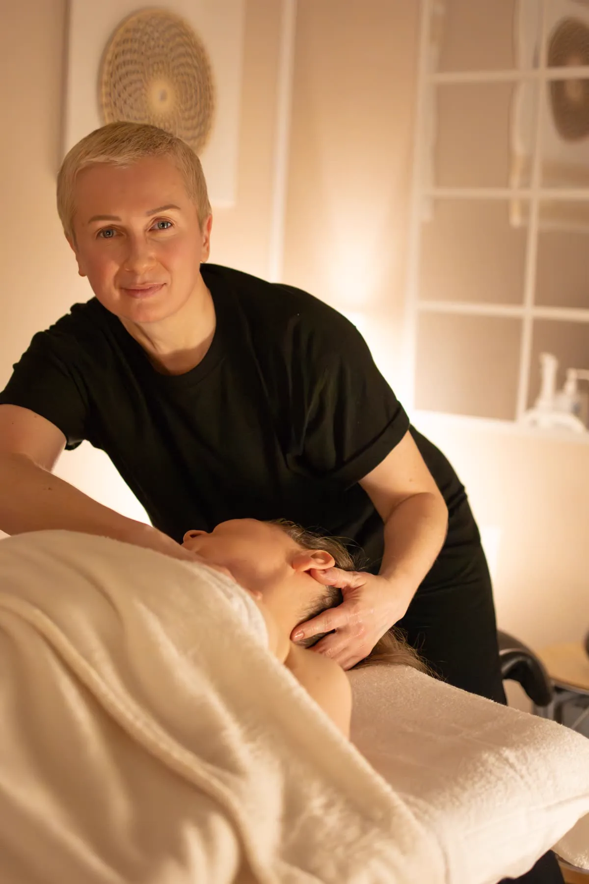 Terapeutka pracuje nad karkiem klientki podczas masażu zdrowotnego w studiu Massage 4 You w Poznaniu